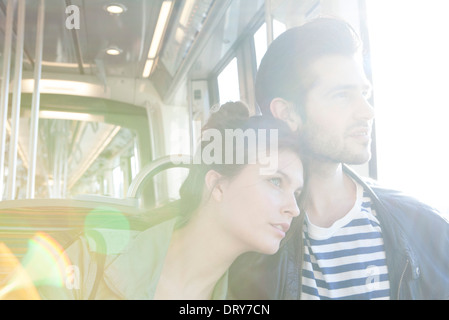 Couple riding train together, looking out window Stock Photo