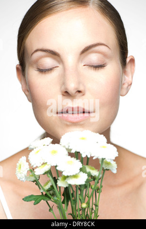 Young woman smelling bouquet of daisies Stock Photo