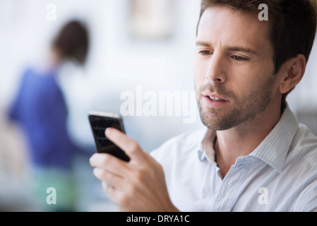 Mid-adult man checking cell phone Stock Photo