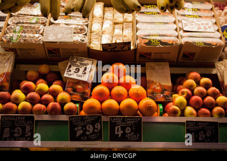 A triangular display of Oranges and Apples on a green grocers market stall. Stock Photo