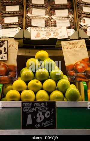 A triangular display of Granny Smith Apples on a green grocers market stall. Stock Photo