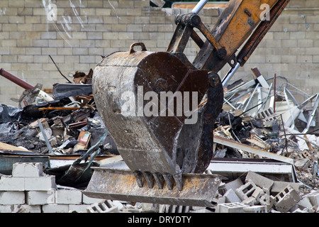 Excavator driver working on construction site digger demolishing building in the city Backhoe Excavator loads rubble in Ohio USA US horizontal hi-res Stock Photo