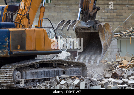 Excavator driver working on construction site digger demolishing building in the city Backhoe Excavator loads rubble in Ohio USA US horizontal hi-res Stock Photo