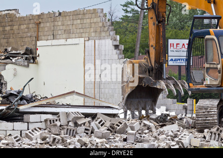Excavator driver working on construction site digger demolishing building in the city Backhoe Excavator loads rubble in Ohio OH USA US hi-res Stock Photo