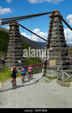 Mountain bikers crossing Historic Kawarau Bridge (Bungy Bridge) on Arrow River Bridges Ride, Otago, South Island, New Zealand Stock Photo