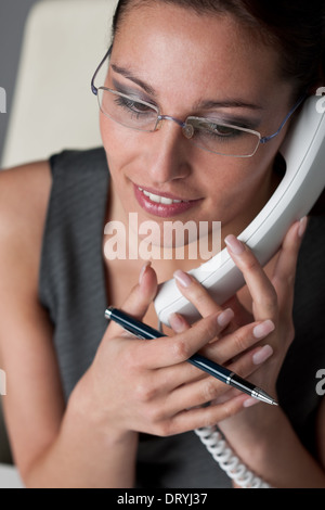 Businesswoman calling on the phone at office Stock Photo