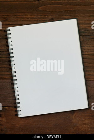 Blank ring bound scrap book on a rustic wooden background with copy space for insertion of your message or design elements. Stock Photo