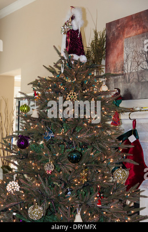 Christmas Tree in front of fireplace mantle with stockings Stock Photo