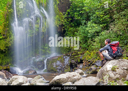 Hiker at a waterfall on the Banks Peninsula Track Stock Photo