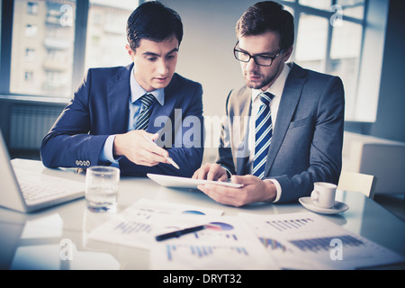 Image of two young businessmen discussing new project in office Stock Photo