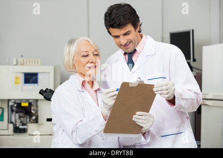 Technicians Writing On Clipboard In Laboratory Stock Photo