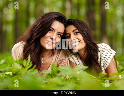 Closeup of mother and daughter laying on blanket at a picnic in a forest Stock Photo