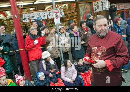 Vancouver, British Columbia, Canada. 4th Feb, 2014. Canada's federal opposition leader THOMAS MULCAIR (NDP) hands out red good luck envelopes as he walks through Chinatown past tens of thousands of onlookers during the 2014 Chinese New Year Parade celebrating the Year of the Horse in Vancouver. Credit:  Heinz Ruckemann/ZUMA Wire/ZUMAPRESS.com/Alamy Live News Stock Photo