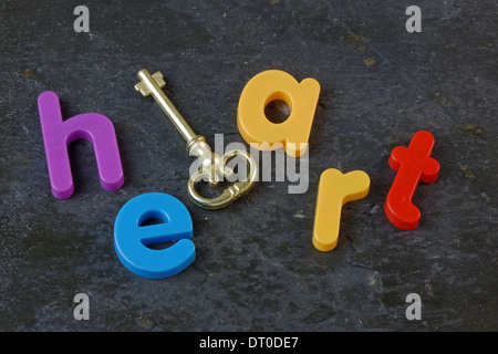 Key and the word heart on a slate background Stock Photo