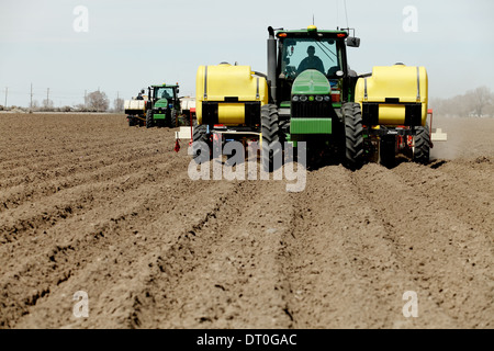 Tractors and other farm machinery working in the fields planting Famous Idaho Potatoes.