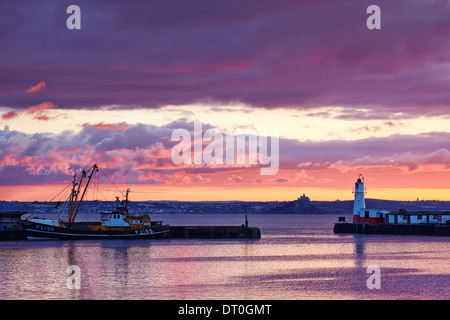 A colourful sky above Newlyn Harbour and Mounts Bay beyond Stock Photo