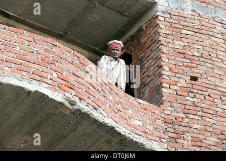 New Delhi, India. 05th Feb, 2014. A resident await the arrival of the German President in an unfinished house in New Delhi, India, 05 February 2014. President Gauck is in India on his six days official visit to strengthen the political and business ties between the two countries. Photo: WOLFGANG KUMM/dpa/Alamy Live News Stock Photo