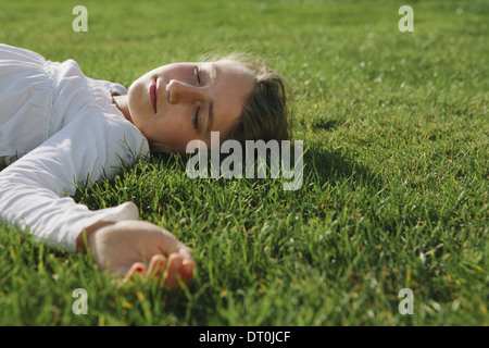 Seattle Washington USA Nine year old girl resting on field green grass Stock Photo