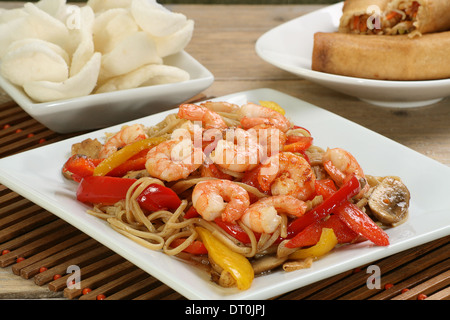 dish of prawn chow mein with crackers and spring rolls Stock Photo