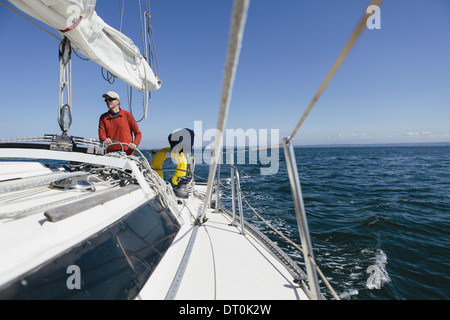 Washington State USA Middle aged man steering sailboat on Puget Sound Stock Photo