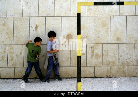 Young Israeli Jewish and Arab kid playing at the playground courtyard of 'Hand in Hand' integrated, bilingual Hebrew-Arabic school for Jewish and Arab children located in West Jerusalem Israel Stock Photo