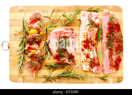 Closeup of spiced raw pork meat on a wooden board, isolated on white background Stock Photo