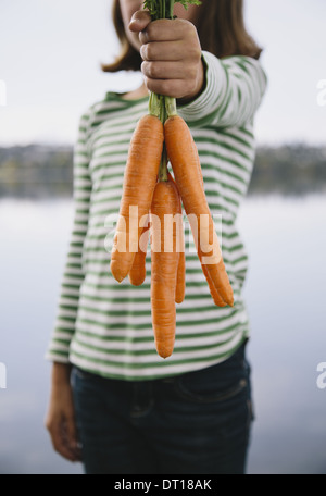Seattle Washington USA Nine year old girl holding organic carrots Stock Photo