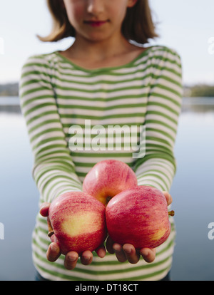 Seattle Washington USA Nine year old girl holding handful organic apples Stock Photo