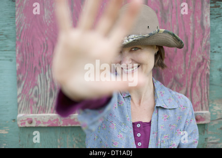 Woodstock New York USA woman in hat holding her hand out to block face Stock Photo