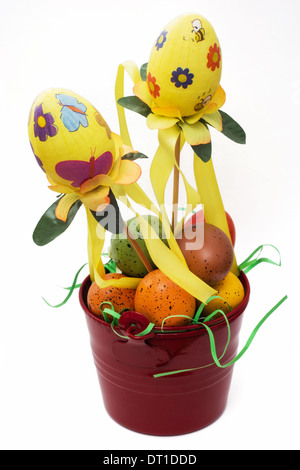 Red bucket with painted easter eggs on a white background. Stock Photo