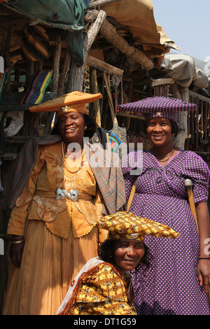 Three Herero tribe women in Namibia,wearing their traditional German era inspired Victorian dress and  cow-horn hats. Stock Photo