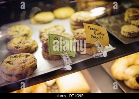 A tray of cookies biscuits and baked goods on the counter at a coffee shop Labels Freshly home baked snacks Stock Photo