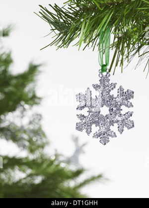 Green leaf foliage and decorations A pine tree branch with green needles Christmas decorations A silver icicle shape Stock Photo