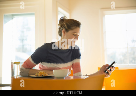 A young girl in a coffee shop Using her cell phone Stock Photo