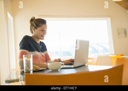 A young girl in a coffee shop using a laptop computer Stock Photo