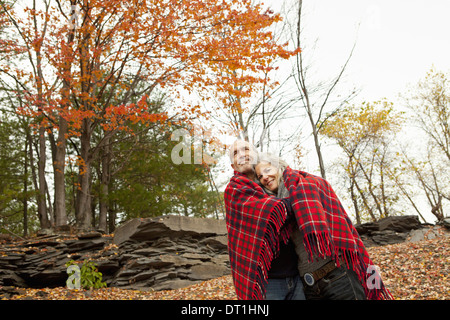 A couple man and woman on a day out in autumn Sharing a picnic rug to keep warm Stock Photo