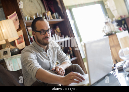 A man sitting at a desk using a laptop computer Running a small business Stock Photo