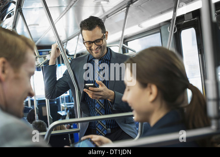 Three people on the move two men and a woman on the bus Stock Photo