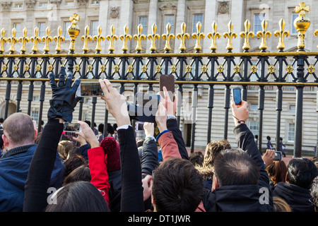 LONDON, UK, 2ND FEB 2014: People being the gates of Buckingham Palace taking photographs and watching the Royal Guards Stock Photo