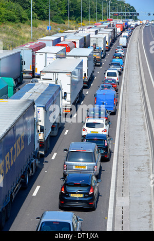 M25 English motorway four lane gridlocked mainly lorries & trucks with articulated trailers stuck in queue because of an accident Essex England UK Stock Photo