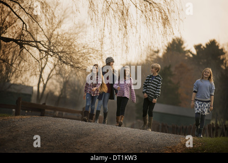 A group of children a boy and four girls walking along a path on a winter's day An organic farm Stock Photo