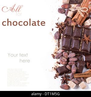 Top view on dark chocolate with cocoa beans, cinnamon and anise over white with sample text Stock Photo