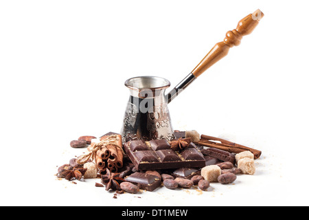 Copper cezve with dark chocolate, cocoa beans, cinnamon and anise isolated over white Stock Photo