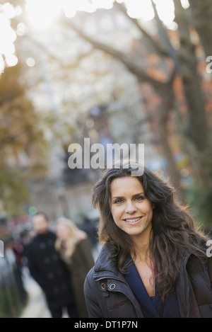 Group walking in urban park woman in front Stock Photo