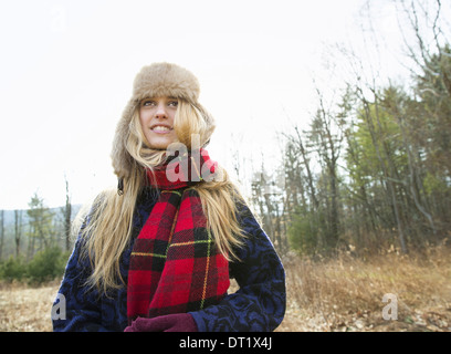 A woman in a warm furry hat and a big red tartan scarf outdoors in the winter Stock Photo