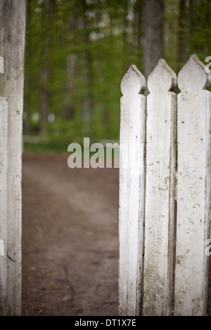 A white picket fence with an open garden gate Stock Photo