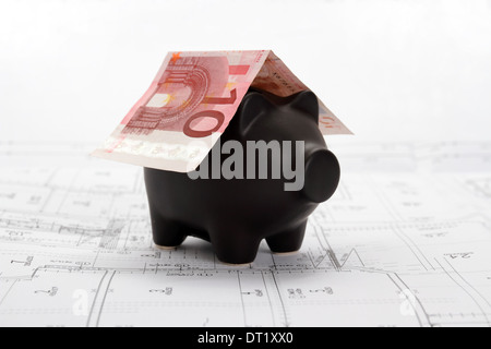 Black piggy bank with roof of Ten Euro Note on house drawing Stock Photo