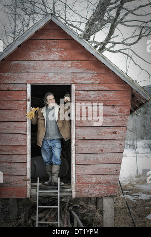 An organic farm in upstate New York in winter A man standing in the doorway of a henhouse Stock Photo