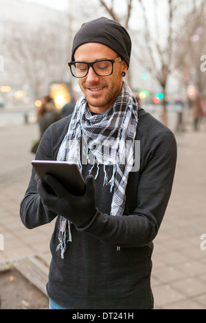 Young man reading messages and information using an i-pad tablet computer. Stock Photo