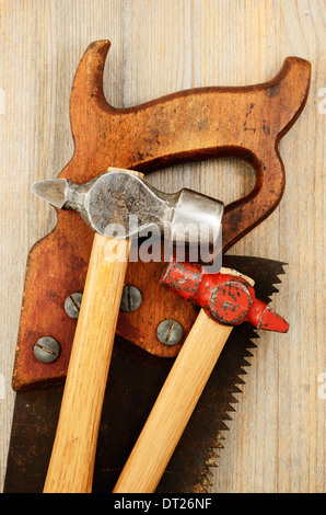 two hammer and old saw on wooden background Stock Photo